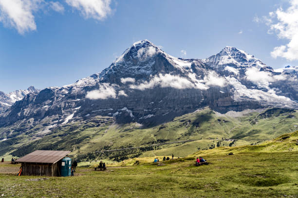 mężczyzna, alpy berneńskie. wędrowcy poniżej północnej ściany eiger. w tle jungfraujoch. - wengen mountain peak eiger field zdjęcia i obrazy z banku zdjęć