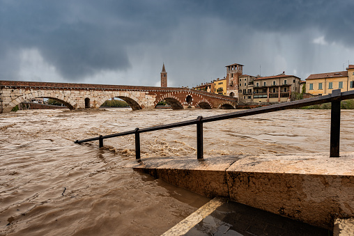 Verona, Ponte Pietra (Stone bridge), I century B.C, and Adige river in flood after several violent storms. UNESCO world heritage site, Veneto, Italy, Europe