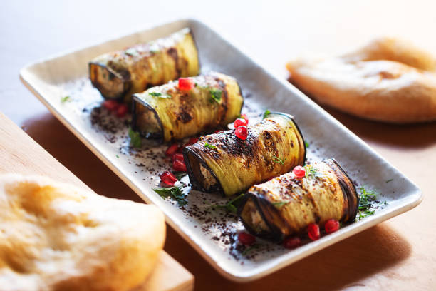 Baked Eggplant Plate Dressed with pomegranate seeds and herbs on the white plate