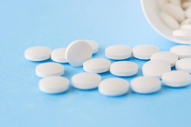 istock White homeopathic pills on a blue background. Close up 1272597040