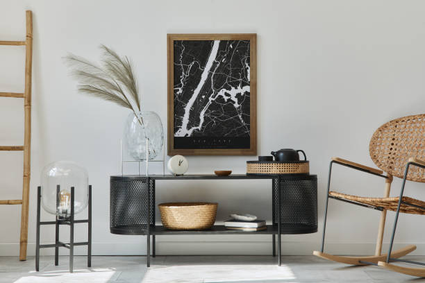 istock Modern scandinavian living room interior with mock up poster frame, design commode, leaf in vase, rattan armchair, book and elegant accessories in stylish home decor. Template. 1272599612