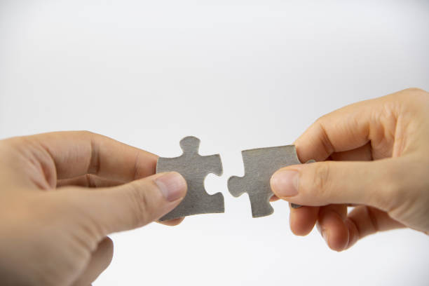istock Two hands are joining the puzzle together 1272602454