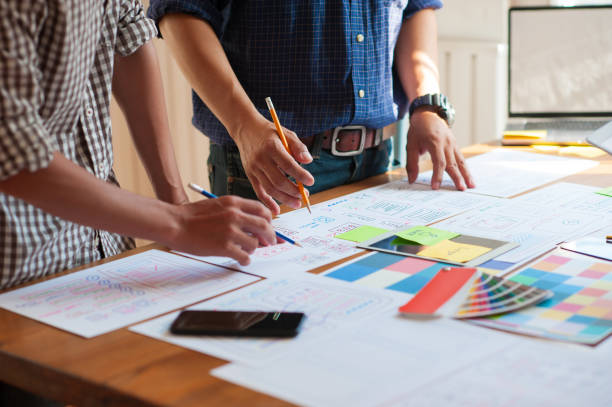 istock Two UX, UI designers discuss to use their creativity to design websites and mobile applications. 1272602632