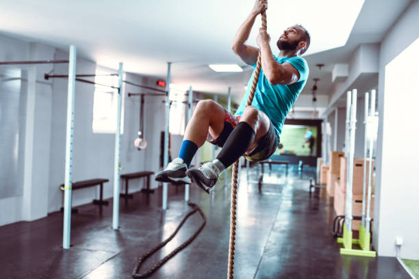 istock Muscular Male Showing How To Climb Rope With Hands Only 1272603733