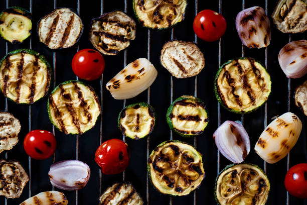 istock Grilled zucchini, tomatoes, onions, peppers and eggplants on a black background 1272605357