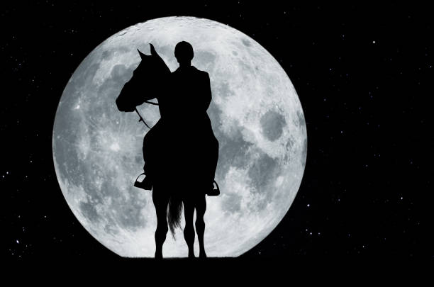 Silhouette of a rider on a horse before full moon