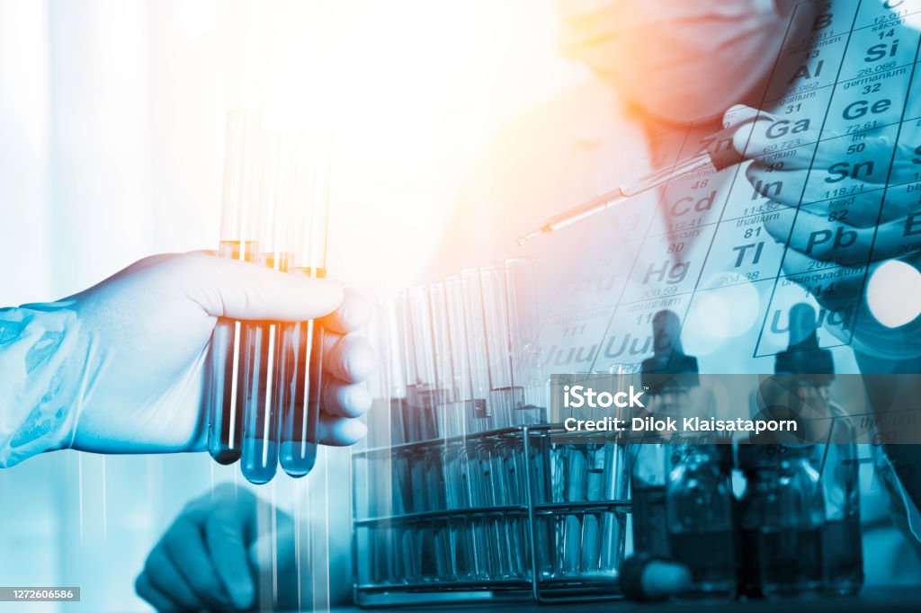 Double exposure of Scientists put a chemical dropper into a test tube and element table during an experiment in a science laboratory Science Stock Photo