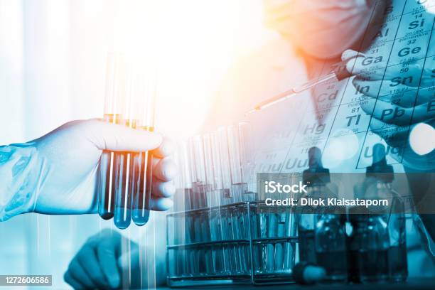 Double Exposure Of Scientists Put A Chemical Dropper Into A Test Tube And Element Table During An Experiment In A Science Laboratory Stock Photo - Download Image Now