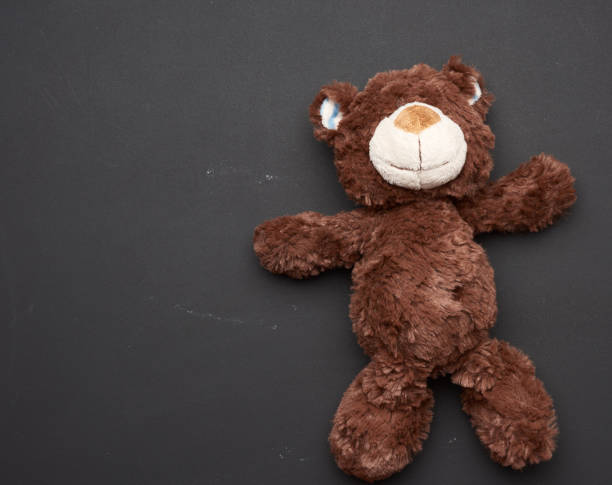 istock brown teddy bear on a black chalk board background 1272607838