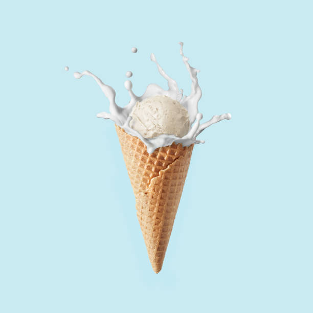 Fresh natural ice-cream in a corn with milk splash against pastel blue background. Waffle corn of fresh natural homemade sweet ice-cream with milk splash against light blue background, copy space. Healthy natural dessert. vanilla ice cream photos stock pictures, royalty-free photos & images
