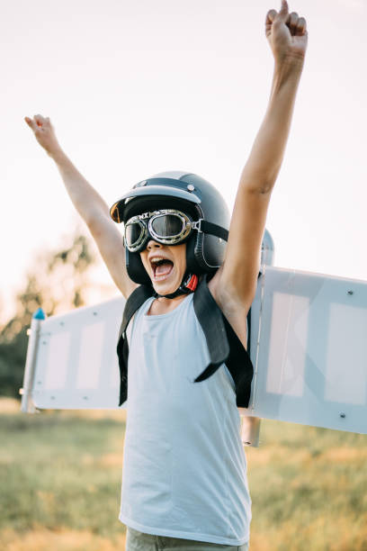 istock Boy wearing jetpack wings playing. Dream of flying. 1272609179