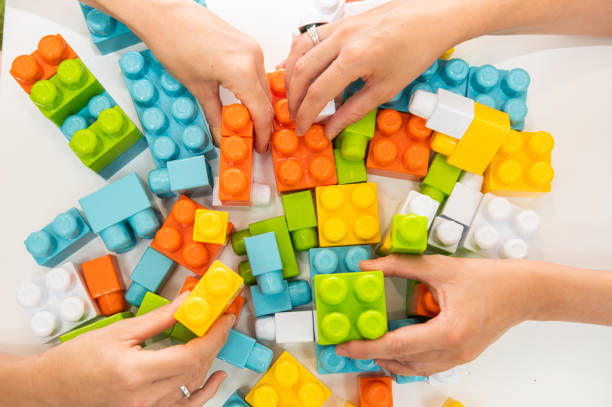 istock Hands placing colorful blocks to start the game at kindergarten 1272611178