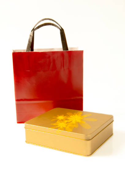 Golden gift box with red handbag on white background