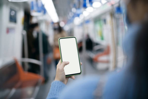 istock Woman holding and using a smart phone on underground train. 1272613515