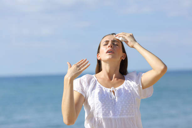 Stressed teen suffering heat stroke on the beach Stressed teen suffering heat stroke on the beach overheated stock pictures, royalty-free photos & images