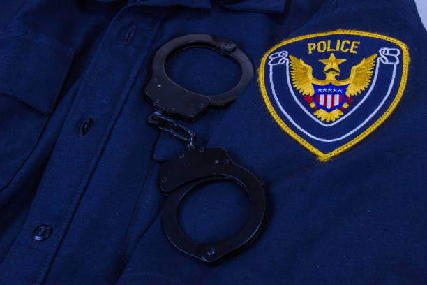 istock Law Enforcement Uniform With Generic Police Patch And Handcuffs 1272613836