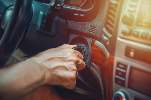 la mano dell'uomo sulla chiave di accensione sta per avviare un suv - accensione foto e immagini stock