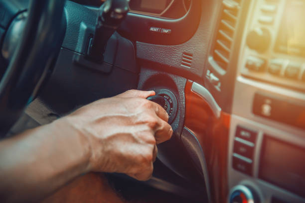 Man's hand on ignition key about to start an suv stock photo