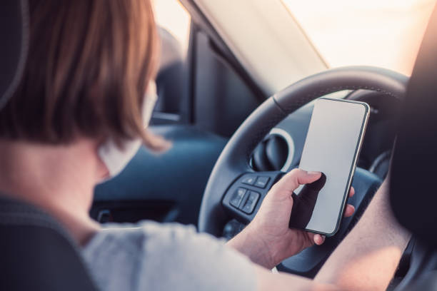 istock Woman with protective face mask texting on mobile phone in the car 1272618740