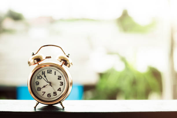 istock Bell alarm clock against blurred outdoor background with copy space for time management concept 1272621918