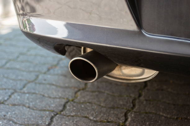 istock Car engine single exhaust metal tip close up shot next to rear bumper 1272624384
