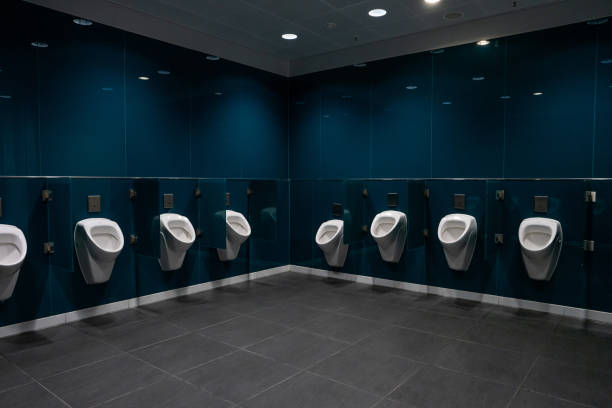 empty men's public toilet room inside international airport terminal - urinal clean contemporary in a row imagens e fotografias de stock