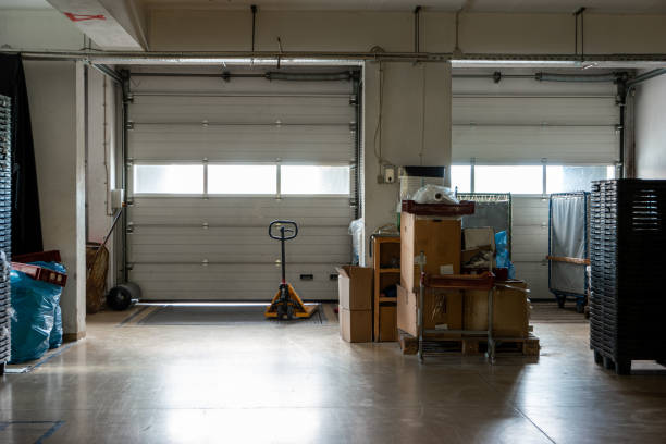 istock Small truck loading bay terminals seen from inside small factory with pallet loader in front 1272625068