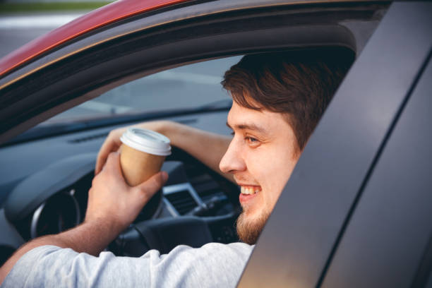 istock A man driving a car drinking coffee 1272627198