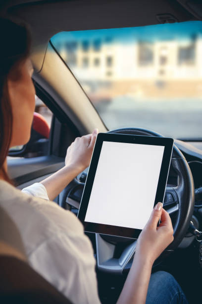 istock Woman in a car with a tablet in hands 1272627225