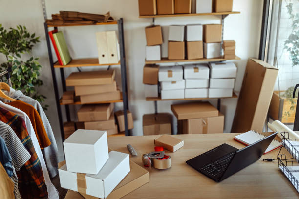 istock Laptop with cardboard boxes ready for e-commerce delivery at clothing warehouse 1272627730