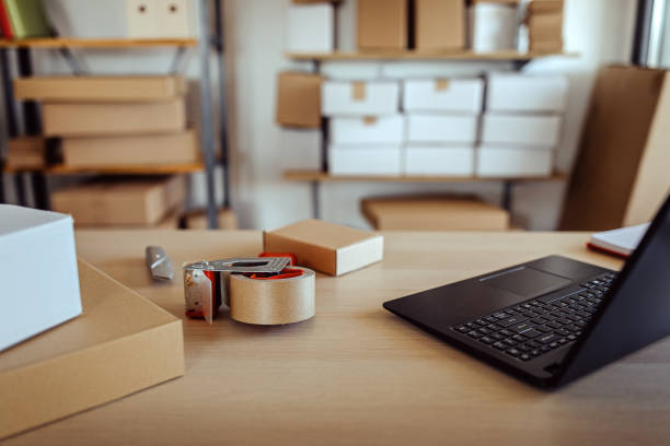 istock Laptop with cardboard boxes ready for e-commerce delivery at clothing warehouse 1272627768