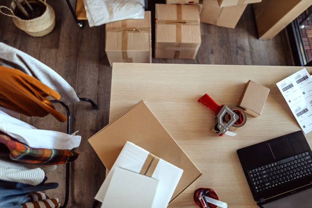 istock Laptop with cardboard boxes ready for e-commerce delivery at clothing warehouse 1272627874