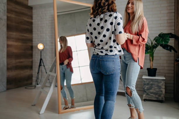 istock Two best friends playing with hat in front of mirror 1272627948