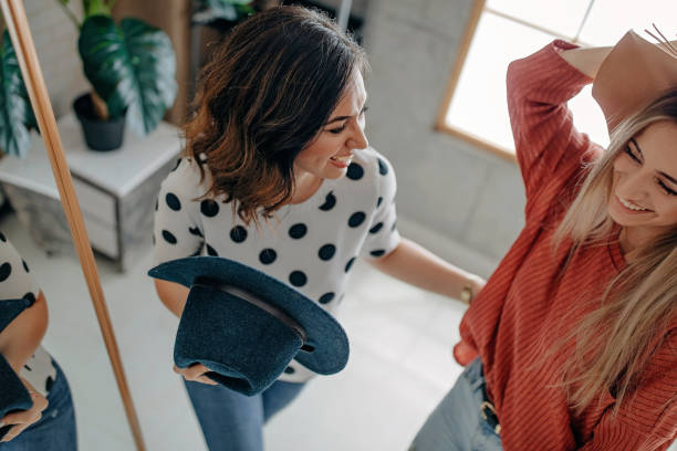 istock Two best friends playing with hat in front of mirror 1272629256