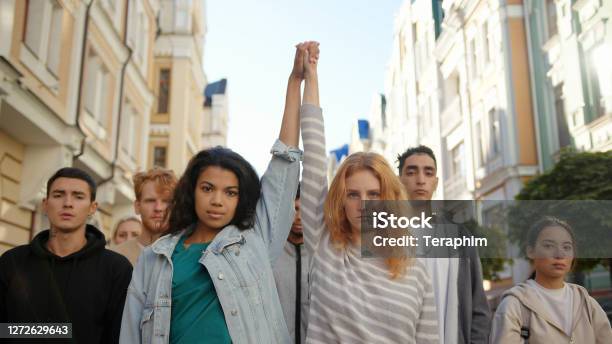 Two Multiracial Women Holding Hands Together And Lift Them Up In Mass Protest Against Racism Stock Photo - Download Image Now