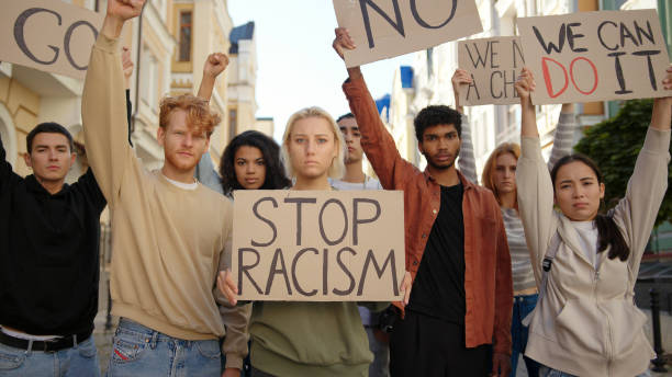 public demonstration at street against racism with slogans on posters. multiethnic people protest - anti racism imagens e fotografias de stock