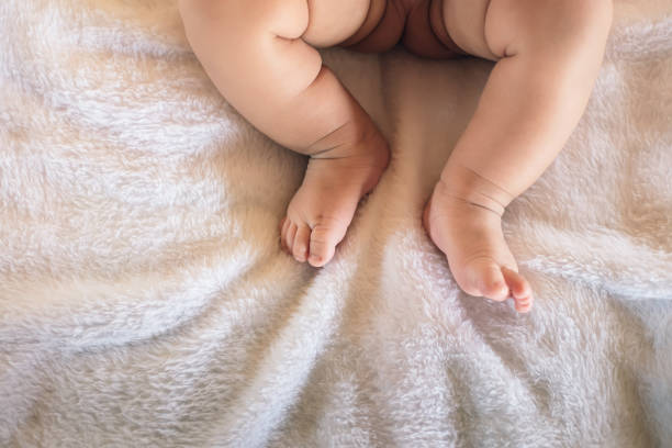 istock Image half body baby feet and legs on the bed. 1272631149