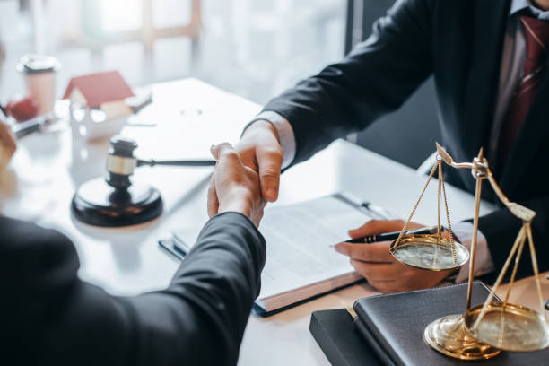 avocat qui fournit des conseils juridiques dans le bureau. homme d’affaires et avocat se serrant la main. - avocat photos et images de collection