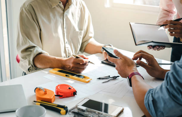 istock Engineer and contractor planning projects together at desk with blueprint. 1272631288