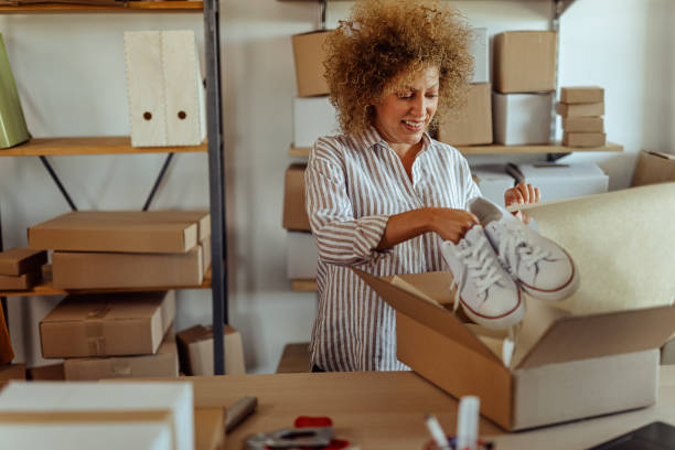 istock Businesswoman preparing to pack shoe at storage warehouse 1272631941