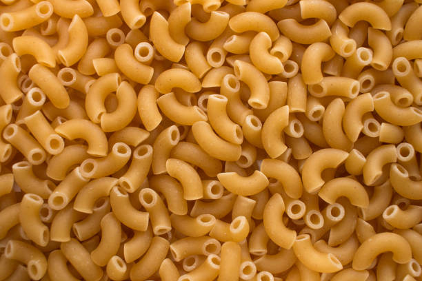 istock Raw elbow macaroni closeup background texture image. Mediterranean food. 1272632001
