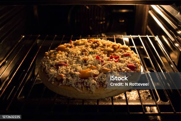 Frozen Pizza Just Went In The Hot Oven Still Frozen And Almost Ready To Eat Stock Photo - Download Image Now