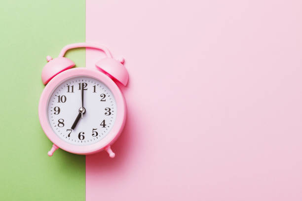 istock Pink alarm clock on a colored background with copy space 1272633775