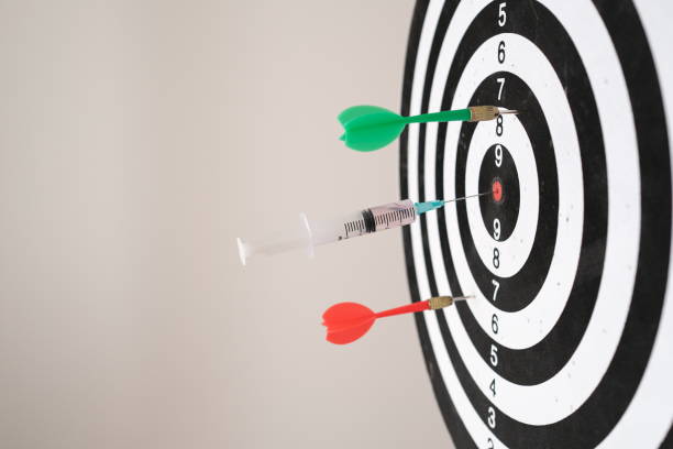 Achieving success with syringes and vaccines. hitting the middle of the dartboard. stock photo