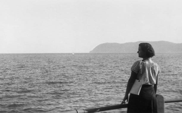 1930s. Alassio Liguria Italy. Young woman posing on the coastline Cute young woman relaxing on the seafront. 1930s black and white film. Alassio, Liguria. Italy mediterranean woman portrait stock pictures, royalty-free photos & images