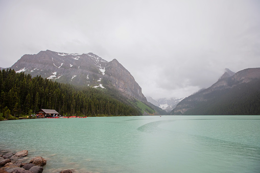Turquoise waters of glacial Lake Louise on a rainy day