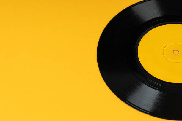 istock Old vinyl disc on yellow background. Old vintage vinyl record. 1272635837