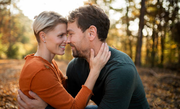 istock Young couple in love on a walk in autumn forest, hugging. 1272638643
