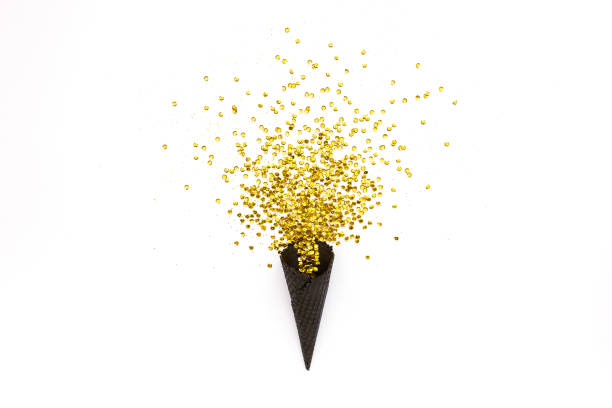 Black waffle cones with golden confetti tinsel isolated on white background. Flat lay, top view minimal festive concept
