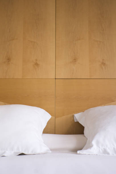istock Pillows with white covers on luxury hotel king size bed. No people 1272649505